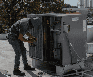 HVAC contractor repairing a faulty AC unit in Gloversville NY