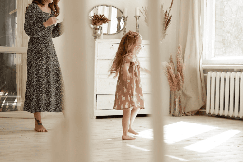 a toddler dancing on a wooden floor.