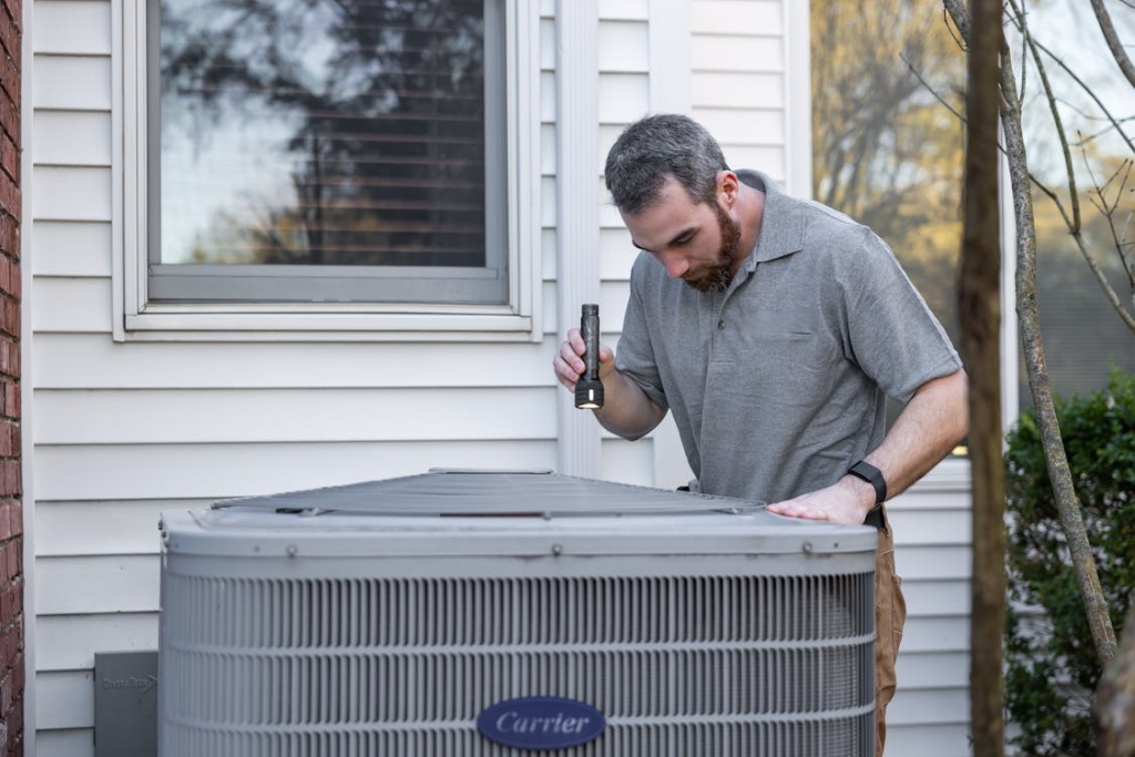 A person checking the outdoor unit of an AC