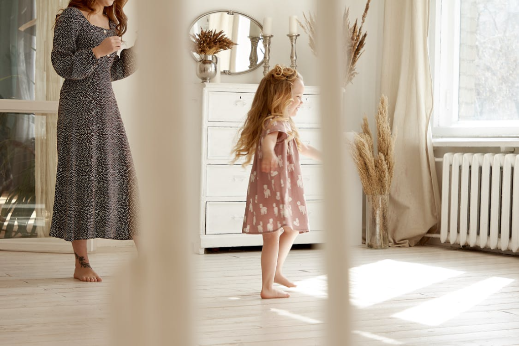 a toddler dancing on a wooden floor.